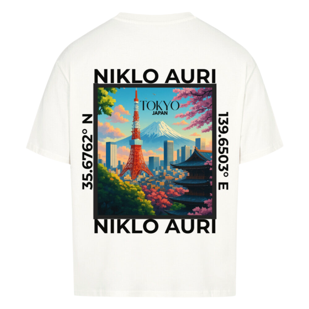 Naturweißes T-Shirt mit farbigem Tokyo-Print auf dem Rücken, eingerahmt von „NIKLO AURI“ und Koordinaten (35.6762° N, 139.6503° E); vorne kleines „NA“-Logo auf der Brust.