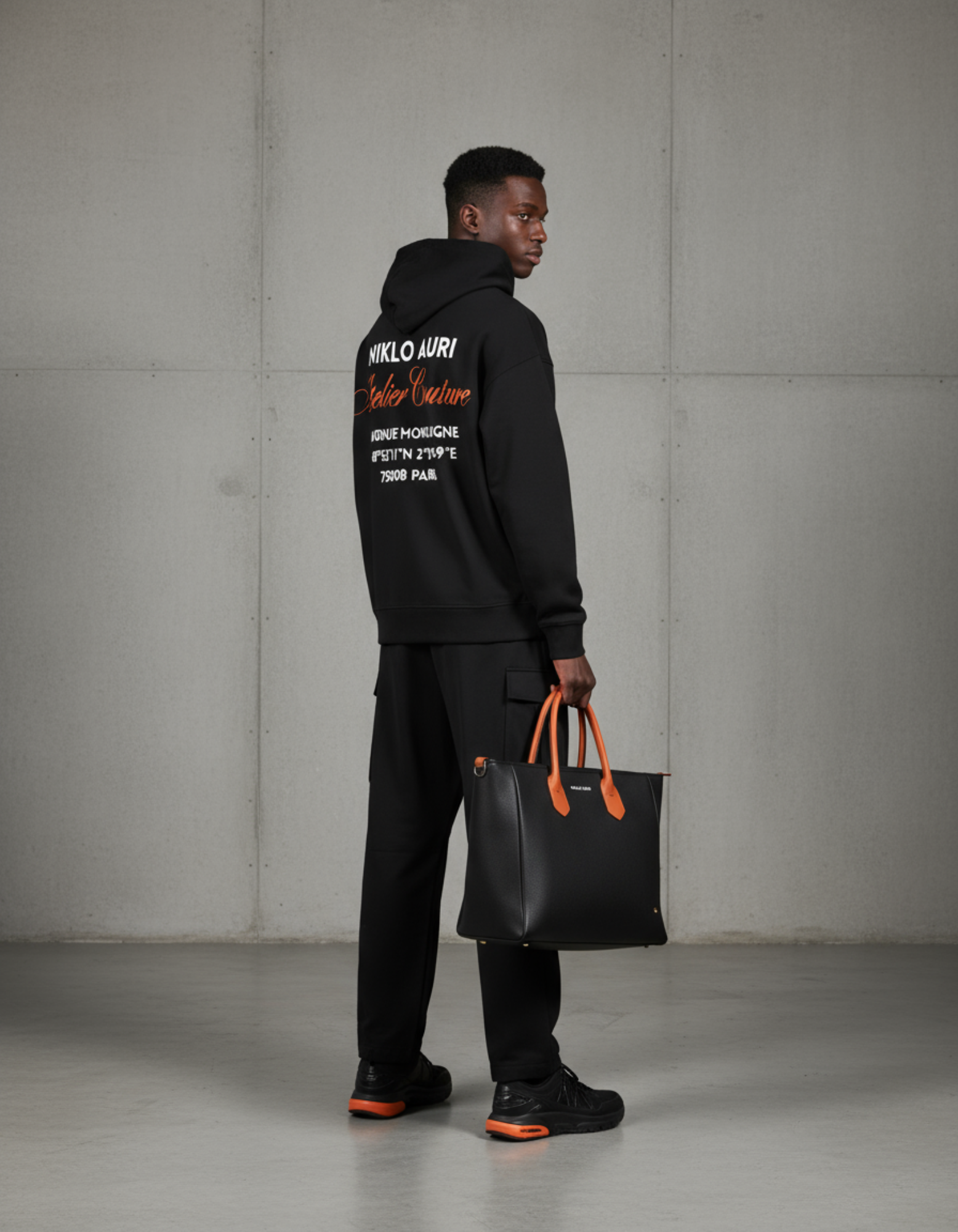 „Model zeigt den Atelier Couture Backprint des Niklo Auri Hoodies.“