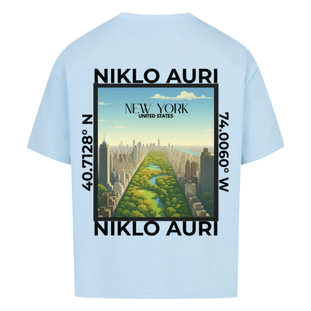 Hellblaues T-Shirt mit Rückendruck eines stilisierten New-York-Motivs (Central Park in Vogelperspektive), eingerahmt von „NIKLO AURI“ und Koordinaten (40.7128° N, 74.0060° W); im Himmel steht „NEW YORK – UNITED STATES“.