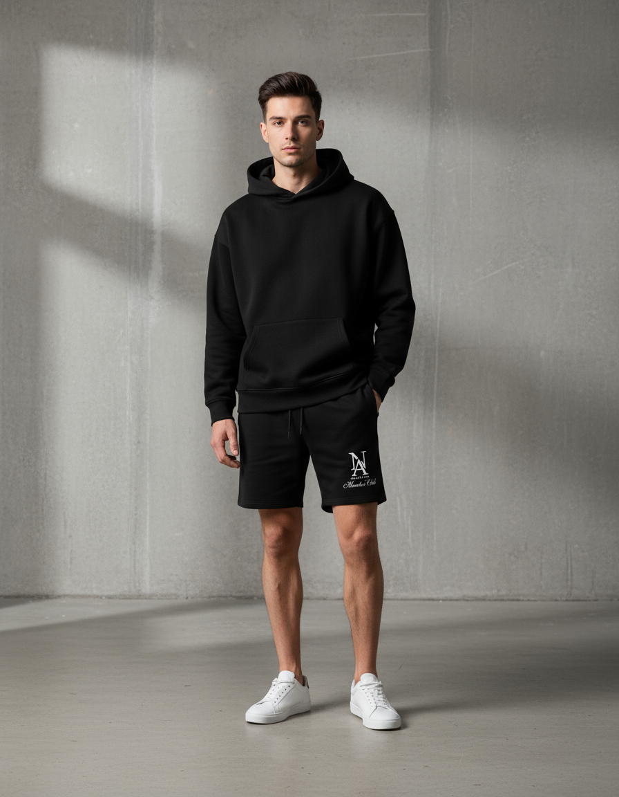„Model trägt Niklo Auri Monogram Script Shorts – urban sport look.“