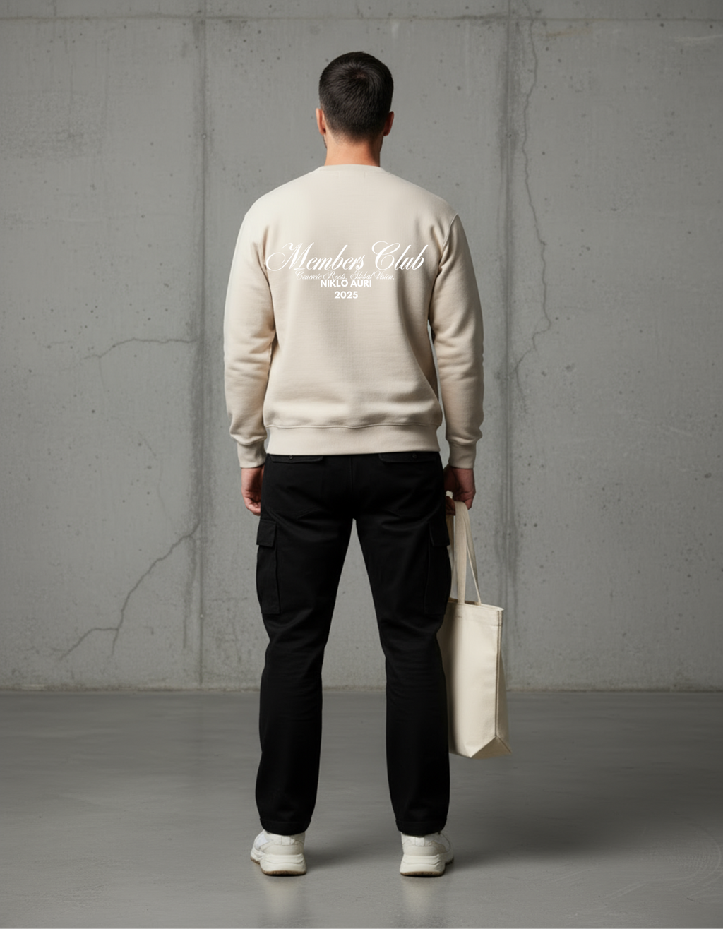 „Model trägt Members Club Sweater in Sand – Oversized Fit.“